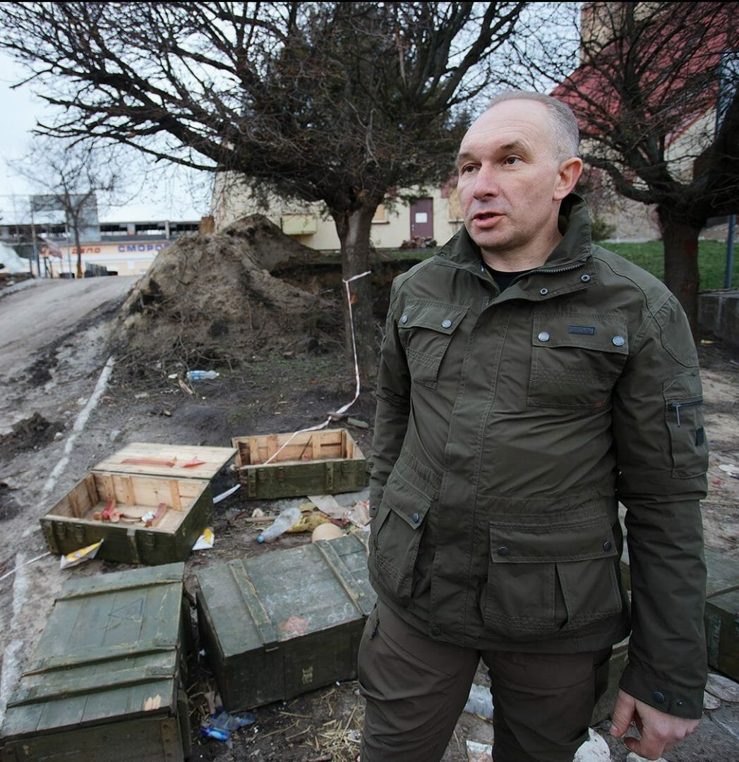 Голова Тростянецької громади Юрій Бова на фоні ящиків з амуніцією, які залишили росіяни під час втечі